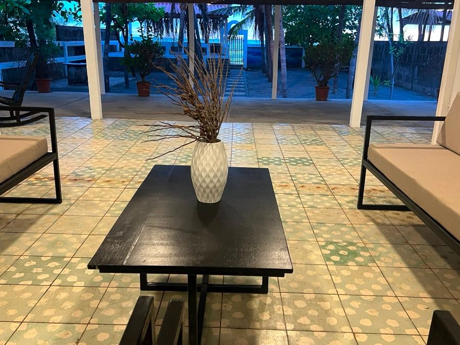 Mesa negra con florero blanco en la terraza.